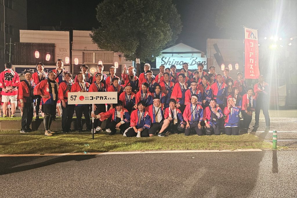 2025年11月2日、おはら祭・夜まつりにて撮影された株式会社コーアガス日本の踊り連集合写真。社員が赤と青のはっぴ姿で記念撮影。
